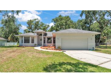 Charming single-story home featuring a well-manicured lawn and an attached two-car garage at 6735 Forestwood W Dr, Lakeland, FL 33811