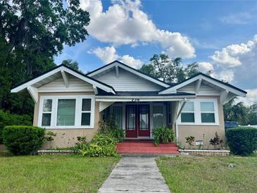 Charming bungalow-style home featuring a front yard with plants, a red front porch, and beautiful architectural details at 236 E Seminole Ave, Lake Wales, FL 33853