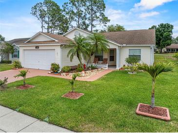 Charming single-story home with a well-manicured lawn, mature palm trees, and lovely landscaping at 3341 Highland Fairways Blvd, Lakeland, FL 33810