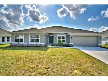 Charming single-story home with gray exterior, well-manicured lawn, and attached two-car garage at 4023 Tullamore Ln, Auburndale, FL 33823