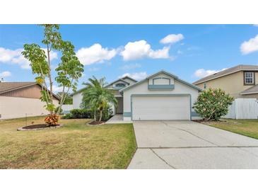 Charming single-story home with a two-car garage, palm tree, and neatly maintained lawn at 412 Emerald Cove Loop, Lakeland, FL 33813