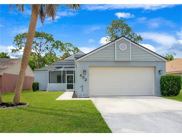 Charming single-Gathering home featuring a two-car garage, well-maintained lawn, and inviting screened porch at 432 Sandestin Dr, Winter Haven, FL 33884