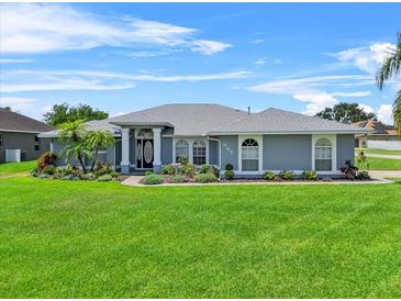Charming single-story home featuring a well-manicured lawn and beautiful landscaping at 647 Hart Lake Dr, Winter Haven, FL 33884
