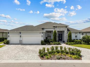 Stunning single-story home featuring a three-car garage and a beautifully landscaped front yard at 6777 Bentridge Dr, Lakeland, FL 33813