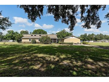 Charming single story home boasts a sprawling lawn and separate detached garage at 7721 Forest Way, Lakeland, FL 33810