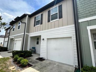 Charming two-story townhome featuring a one-car garage and inviting neutral color palette at 879 Grandin St, Davenport, FL 33837