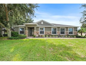 Charming home with stone accents, well-manicured lawn, and lush landscaping creating great curb appeal at 1001 Lena Run Ct, Winter Haven, FL 33880