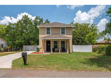 Inviting two-story home featuring a well-manicured lawn, cozy porch, and classic architectural design at 1105 Watersedge Dr, Lakeland, FL 33801