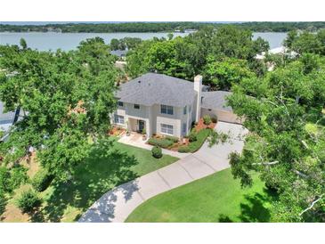 Aerial view of a beautiful two-story home with a well-manicured lawn and lush landscaping near a lake at 1218 Lake Point Ter, Lakeland, FL 33813