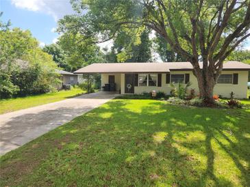 Charming single-story home featuring a well-maintained lawn and mature trees providing shade at 220 Pinehurst Dr, Auburndale, FL 33823
