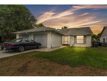 Charming single-story home featuring a two-car garage and well-maintained lawn at sunset at 2526 Fabry Cir, Orlando, FL 32817