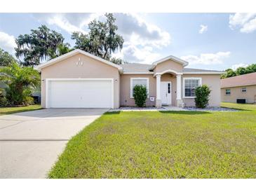 Charming single-story home with manicured lawn, well-lit driveway and an attached two car garage at 3281 Enclave Blvd, Mulberry, FL 33860