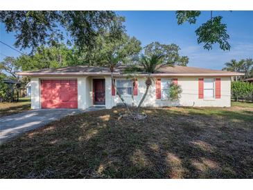 Charming single-story home with a red garage door and a well-maintained front yard at 526 Marklen Loop, Polk City, FL 33868