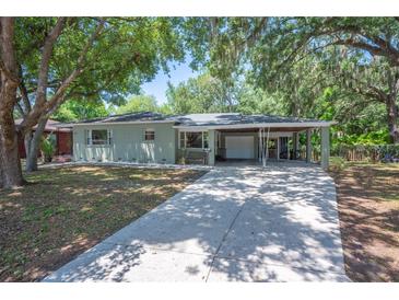 Charming home featuring a large driveway, a carport, and mature trees, offering a serene and inviting atmosphere at 921 Avon Ave, Lakeland, FL 33801