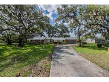 Charming brick home with mature trees and a long driveway at 1317 Old Polk City Rd, Lakeland, FL 33809