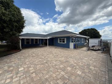 Inviting blue single-story home featuring a spacious brick driveway and well-maintained landscaping at 1328 Edgewater Beach Dr, Lakeland, FL 33805