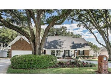 Charming one-story home featuring manicured landscaping and a mature tree canopy at 1516 Jae Pl, Lakeland, FL 33803