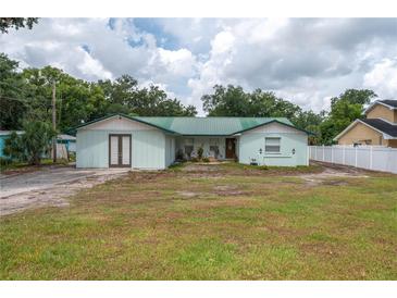 Quaint single-story home featuring a green metal roof and spacious front yard ready for landscaping at 2219 New Jersey Rd, Lakeland, FL 33803