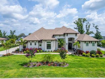 Stunning two-story home with manicured lawn, mature trees, and colorful flower beds offering great curb appeal at 2662 Delphi Hills Ct, Lakeland, FL 33812