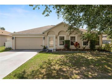 Charming single-story home with a well-maintained lawn, mature trees, and an attached two-car garage at 5733 Oakwood Knoll Dr, Lakeland, FL 33811