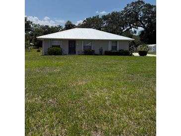 Charming single-story home with a large lawn and mature trees in a serene setting at 629 N Cleveland Ave, Fort Meade, FL 33841