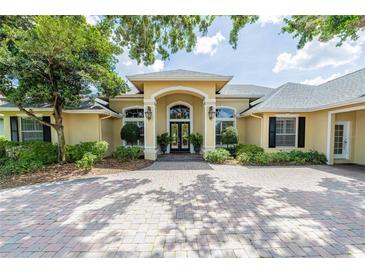 Elegant single-story home featuring a grand entrance, lush landscaping, and a spacious circular driveway at 645 Whisper Woods Dr, Lakeland, FL 33813