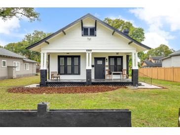 Charming bungalow with black and white trim, inviting front porch and well-maintained front yard at 911 S Missouri Ave, Lakeland, FL 33803