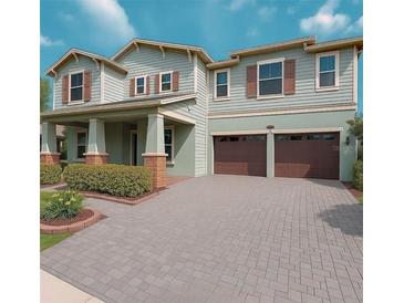 Charming two-story home featuring a two-car garage, covered porch, and inviting curb appeal at 13525 Gorgona Isle Dr, Windermere, FL 34786