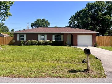 Charming single-story brick home with a well-manicured lawn and attached garage at 2323 Ridgeview Dr, Lakeland, FL 33810