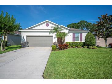 Charming single-story home featuring a well-manicured lawn and a two-car garage at 4303 Moon Shadow Loop, Mulberry, FL 33860
