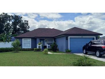 Charming single-story home with a well-maintained lawn, blue paint, and a cozy front porch at 455 Eagle Dr, Kissimmee, FL 34759
