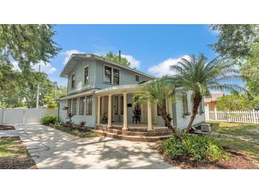 Charming light blue two-story home with a welcoming rounded porch and meticulously maintained landscaping at 516 Windsor St, Lakeland, FL 33803