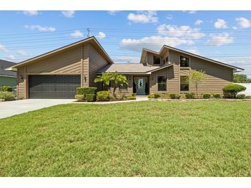 Inviting single-Gathering home featuring a well-manicured lawn and an attached two-car garage at 5519 Club W Hl, Lakeland, FL 33812
