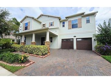 Inviting two-story home featuring a brick driveway and meticulous landscaping at 13525 Gorgona Isle Dr, Windermere, FL 34786