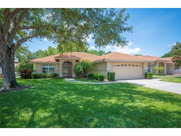 Charming one-story home with a tile roof, manicured lawn, and mature shade tree in a sunny setting at 188 Morning Dew Ct, Winter Haven, FL 33884