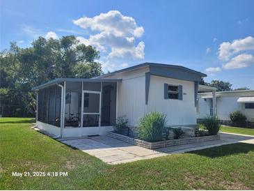 Charming single-story home with a screened-in porch and well-maintained landscaping at 2005 Blue Lake Dr, Lakeland, FL 33801