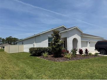 Charming single-story home featuring a well-manicured lawn, white exterior, and a two car garage at 3966 Willowbrook Dr, Edgewater, FL 32141