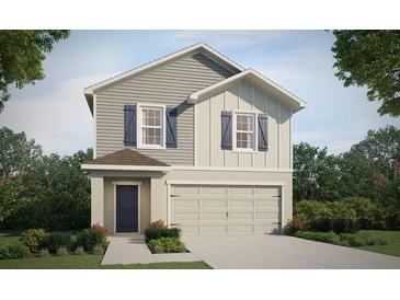 Charming two-story home with gray siding, blue shutters, and a two-car garage, surrounded by lush landscaping at 4482 Rapallo Ave, Winter Haven, FL 33884
