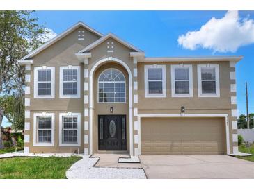 Charming two-story home with a manicured lawn and a two-car garage, featuring a classic architectural design at 5163 Spanish Oaks Dr, Lakeland, FL 33805
