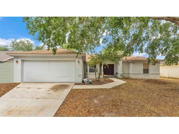 Charming single-story home with a two-car garage, well-maintained lawn, and mature shade trees at 7311 Briarbay Loop, Lakeland, FL 33810