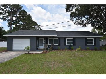 Charming single-story home featuring a brick facade, well-manicured lawn, and inviting front porch at 5732 Sawyer Rd, Lakeland, FL 33810