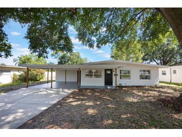 Charming single-story home boasting a carport, a dark front door and large windows at 3813 Surrey Dr, Orlando, FL 32812