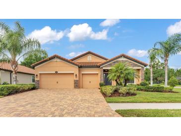 Beautiful home featuring a brick driveway, a two-car garage, and manicured landscaping at 3934 Aquilla Dr, Lakeland, FL 33810