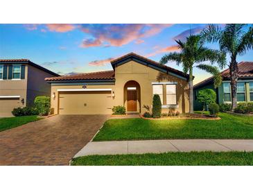 Charming home with a well-manicured lawn, brick driveway, beautiful landscaping, and neutral color palette at 4088 Prima Lago Cir, Lakeland, FL 33810