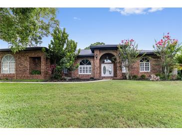 Charming single-story brick home with lush front lawn and mature landscaping at 4642 Highlands Place Dr, Lakeland, FL 33813