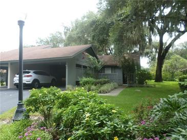 Charming home with a carport and lush landscaping, creating an inviting curb appeal at 6632 Sweetbriar Ln, Lakeland, FL 33813