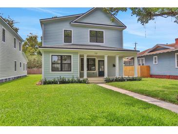 Charming two-story home with a well-manicured lawn, covered porch, and light-blue siding at 727 S Missouri Ave, Lakeland, FL 33815