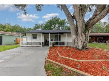 Charming one-story home with a welcoming porch and landscaped front yard featuring a beautiful mature shade tree at 113 Patrick Henry Rd, Bartow, FL 33830