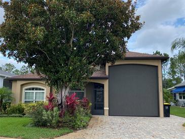 Charming single-story home with a well-maintained lawn, paver driveway, and mature landscaping at 1167 Motorcoach Dr, Polk City, FL 33868