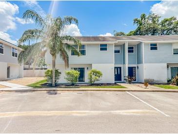 Two-story townhouse with light blue siding, white accents, and a well-maintained landscaped front at 222 Carpenters Way # 65, Lakeland, FL 33805